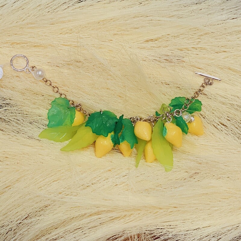 This lemon bracelet is absolutely adorable! Handmade by Kelli Hawk Designs, it features lemon charms alongside clear beads. This is all on a silver 7 inch chain!