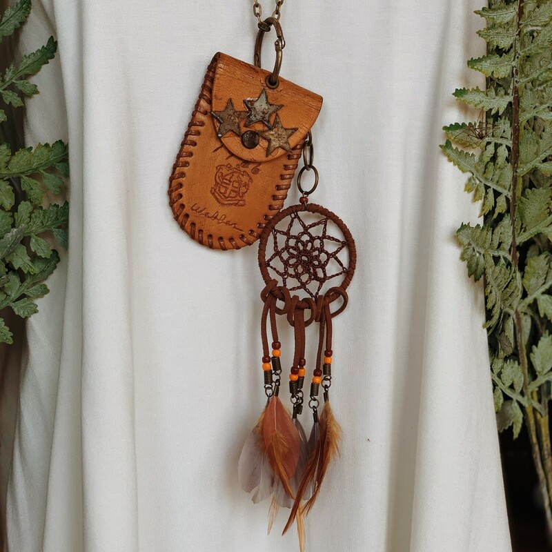 This one of a kind, handmade necklace is on a 28 inch chain and has a leather pouch as the pendant with a feather dream catcher hanging from it!