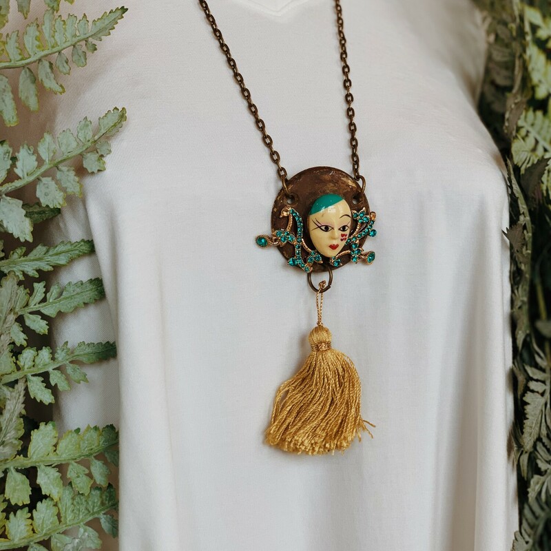 This one of a kind, handmade necklace is on a 26 inch chain and features a porcelain face on the front of an antique knob piece!