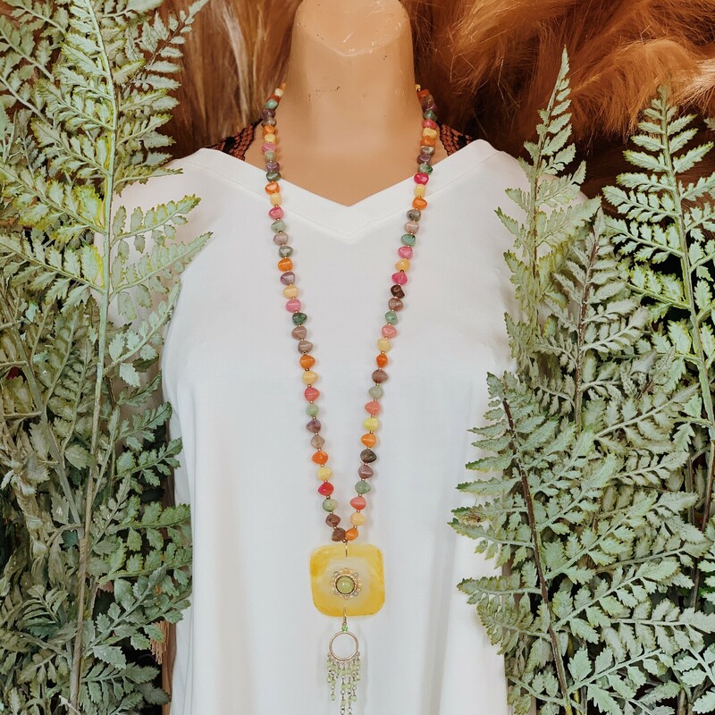 This one of a kind, handmade necklace is on a 35 inch beaded strand and has a shell piece as the pendant with a charm hanging from it!