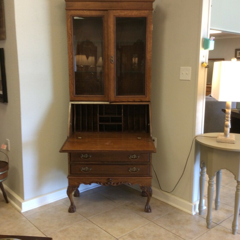 This dropfront secretary is beautiful! It features a dark wood finish and includes 3 drawers, 2 swinging glass doors, 2 glass non-adjustable shelves, and file storage. The desk includes file holders, cubbies and a writing desktop. The secretary is topped off with vintagy brass hardware. Keys included.