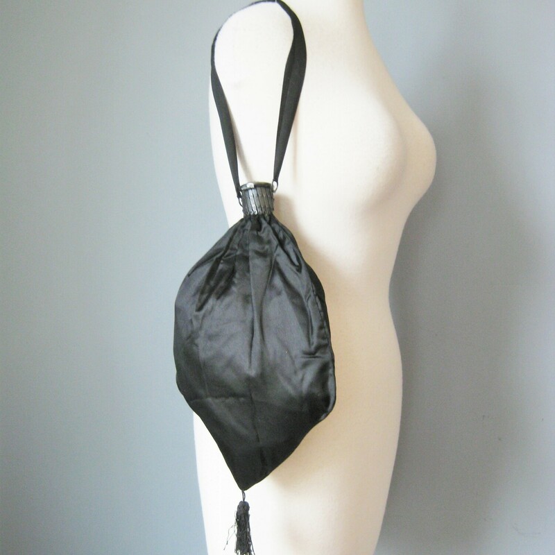 Very old silk purse, probably used as part of a Victorian or Edwardian mourning ensemble.
This back is black with black satin ribbons and a metal expanding frame.
The frame is topped with an open work metal cap with rhinestones.
It has a dangling tassel at the bottom.
The frame opens to reveal a dark lavender silk lining.
Handmade.

Amazing condition! no flaws

10 wide at its widest point
13 long/tall
8 long
12 around

thanks for looking!
#47337