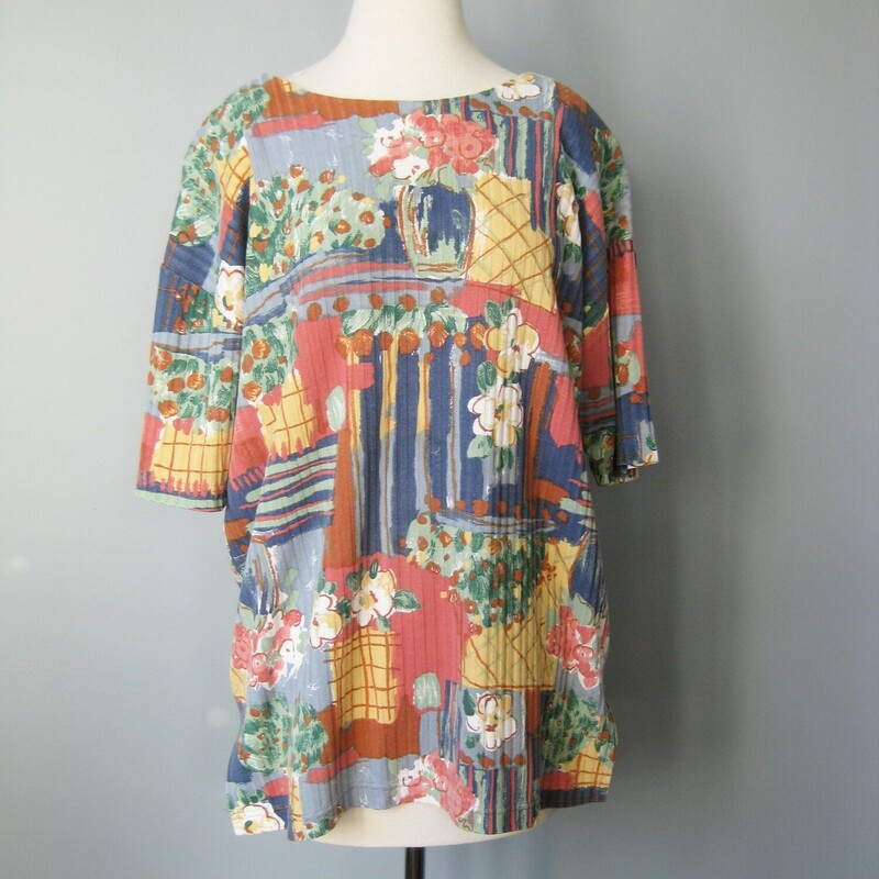 Pretty top in a painterly abstract gardeny print<br />
Mainly blues and oranges<br />
It's a bit long and has slits on the sides so it would look good worn untucked.<br />
Short Sleeves<br />
the fabric is ribbed, substantial  50/50 cotton poly blend.<br />
Shoulder pads<br />
<br />
It's by Jacque & Koko and was made in the USA<br />
<br />
Flat Measurements please double where appropriate:<br />
Shoulder to shoulder: 18 the shoulder seam is dropped, the 18 is the measurement from the outer edge of each shoulder pad, but the actually shoulder seam is a couple of inches below that.<br />
Armpit to Armpit: 24<br />
length: 27.75<br />
width at hem: 24.5<br />
<br />
Pefect condition!<br />
Thanks for looking.<br />
#41804