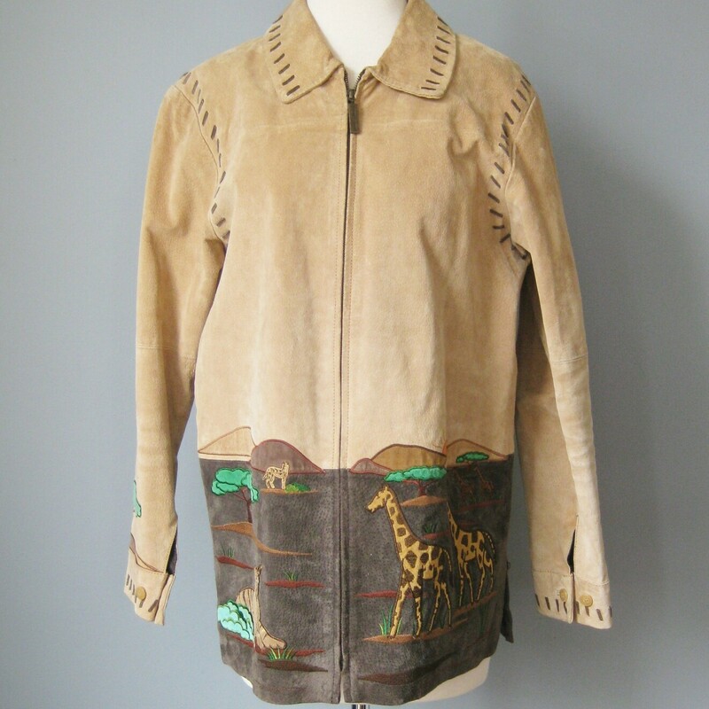 Charming jacket with beautifully rendered scenes from the African Savannah.<br />
It's suede, made from pigskin by Quacker Factory.<br />
<br />
This coat has a low nap suede feel and the skins, as is typical for pigskin, is a little stiff.<br />
It's covered with beautifully rendered, perhaps a little idealized, peacefull African Savanna scenes featuring, giraffe, elephant, cheetah.<br />
<br />
Lined, zip closure<br />
<br />
Interior flat measurements of the garment:<br />
shoulder to shoulder: 17<br />
armpit to armpit: 22<br />
width at hem: 21 3/4<br />
underarm sleeve seam: 18<br />
length: 28.5<br />
<br />
Thanks for looking!<br />
#42822