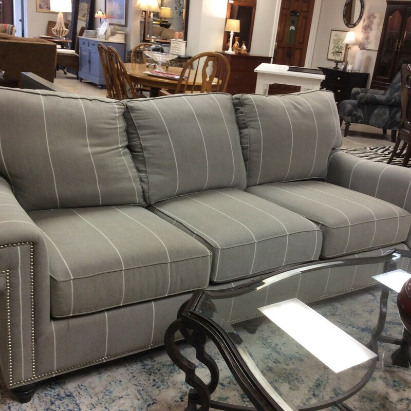 This is a Grey with White stripe 3 seater linen Bassett Sofa. This Sofe features Nailhead trim and dark brown wood circled feet.