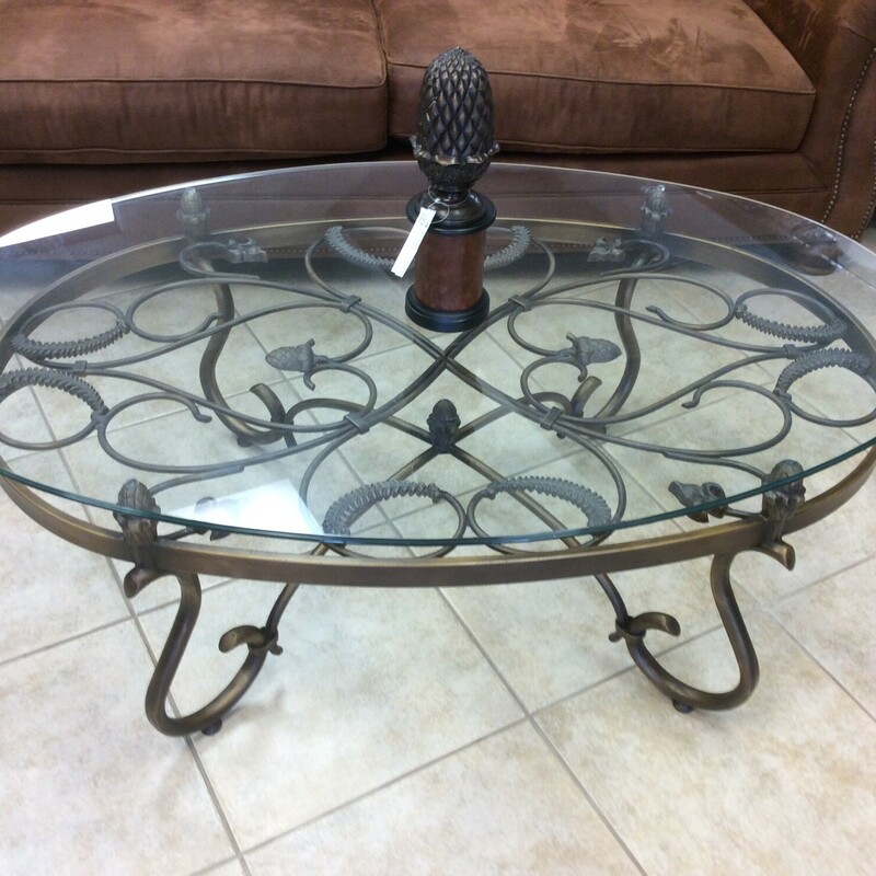 This is a Oval Metal Coffee Table, with a Glass Top. The Metal has acorn and feather detailing.