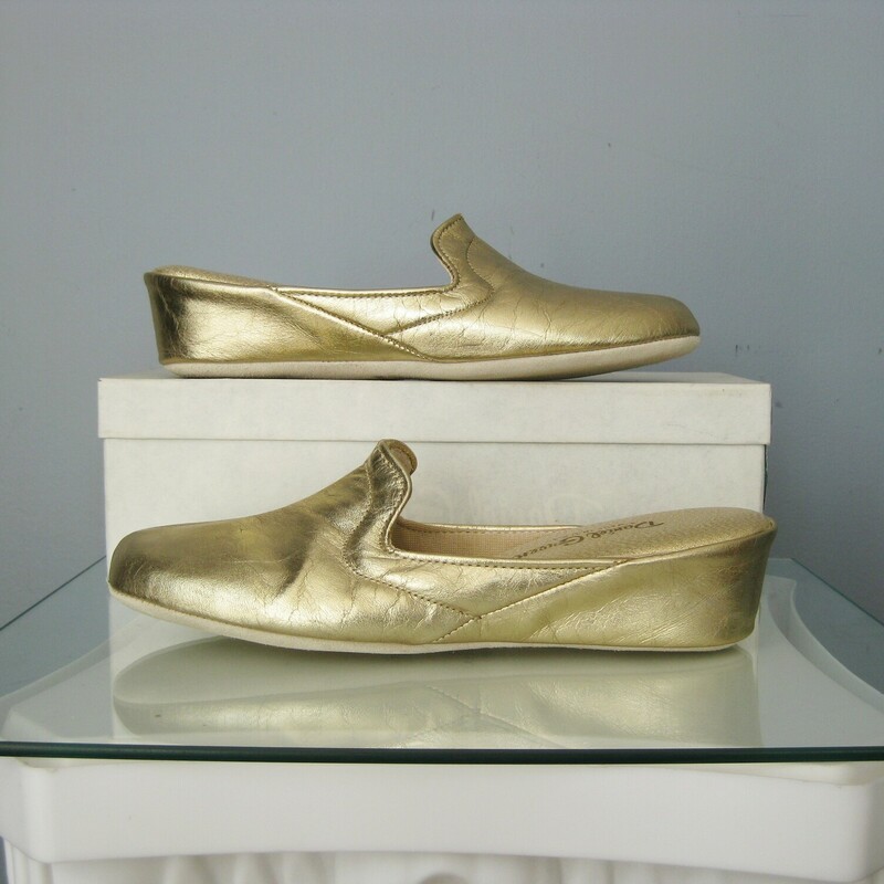 NOS Vtg D Green Slippers, Gold, Size: 8<br />
You are looking at a new  pair of Daniel Green slippers from the 1980s<br />
The box declares them as Joli.<br />
They'are size 8 with metallic gold leather uppers and leather outsoles.<br />
<br />
<br />
Thanks for looking!<br />
#46203