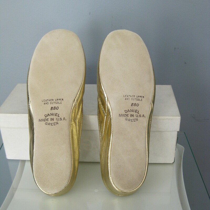 NOS Vtg D Green Slippers, Gold, Size: 8<br />
You are looking at a new  pair of Daniel Green slippers from the 1980s<br />
The box declares them as Joli.<br />
They'are size 8 with metallic gold leather uppers and leather outsoles.<br />
<br />
<br />
Thanks for looking!<br />
#46203