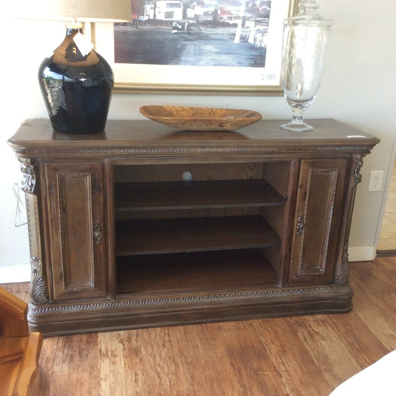This is a Grey Weatherd Wood Media Cabinet with Arch Trim Detail. The Cabinet has 2 side Cabinet Doors and 3 Shelfs in the middle of the cabinet.
