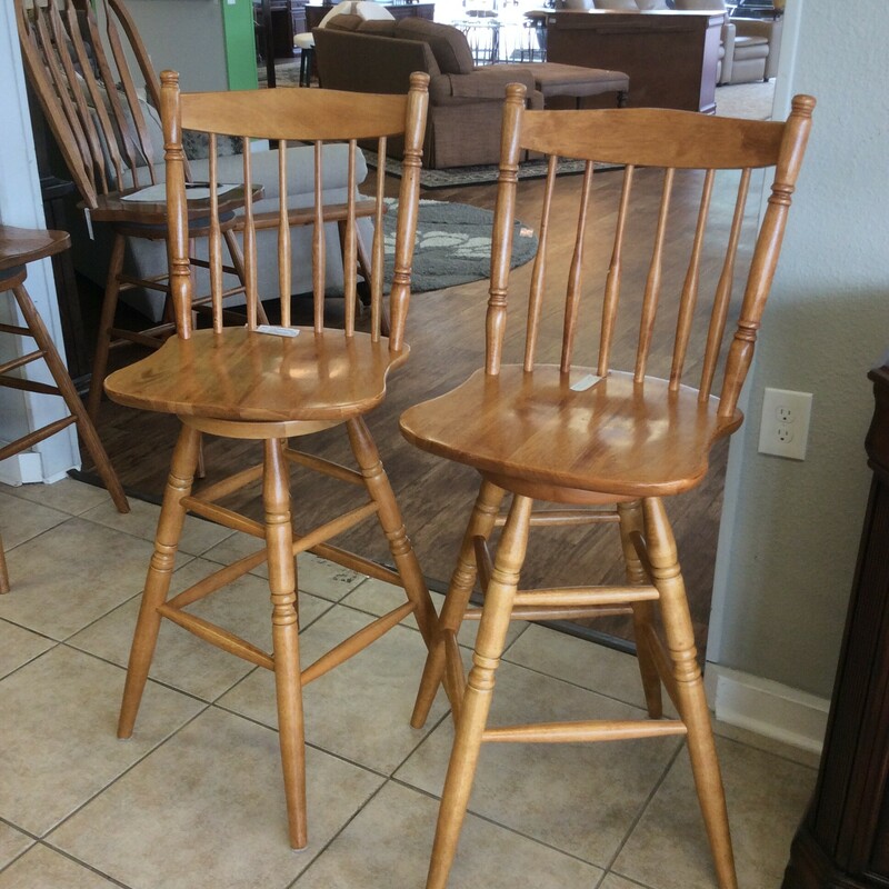 These are a beautiful pair of oak stained Bar Stools. They have beautiful round detailing and the chairs swivel.
