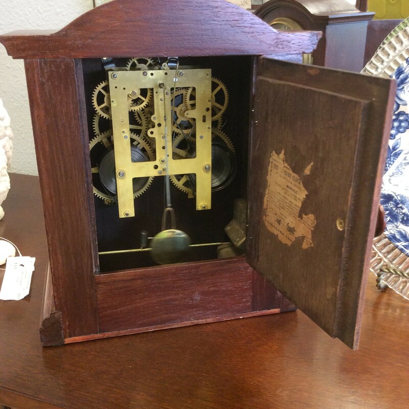 This is a Antique Mantel Clock with a beautiful dark finish. The Mantel Clock has a golden face and includes a Key to wind up the clock.