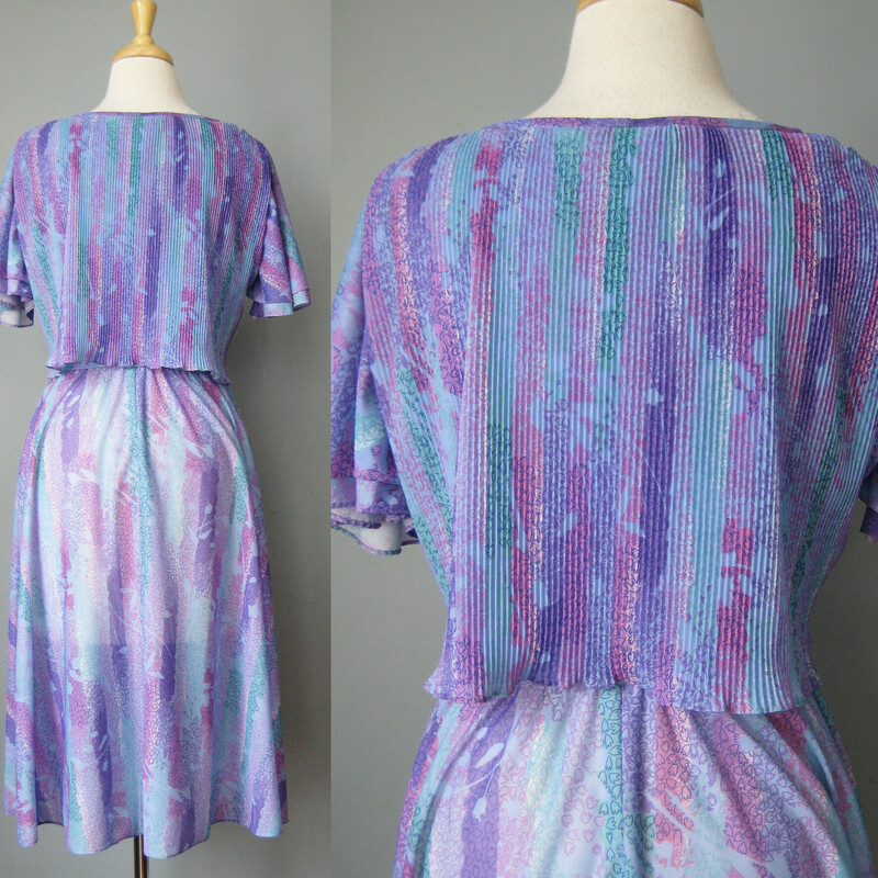Vtg 70s Floral, Lilac, Size: Small<br />
Sweet below the knee dress in a very lightweight polyester.<br />
Abstract print in purples and blues.<br />
The dress has an elastic waist and a micro pleated capelet.<br />
Flutter sleeves and matching sash<br />
The skirt is sheer so you will need a half slip with it.<br />
No labels but I believe this is from the late 70s, on the cusp of disco fever and it reminds me of the dresses worn by the heroine of Saturday Night Fever.<br />
<br />
Here are the flat measurements, please double where appropriate:<br />
Shoulder to shoulder: 15.5<br />
Armpit to Armpit: 20<br />
Waist:  13 stretches comfortably to 16<br />
Hip: free<br />
length: 39<br />
<br />
Thanks for looking!<br />
#41301