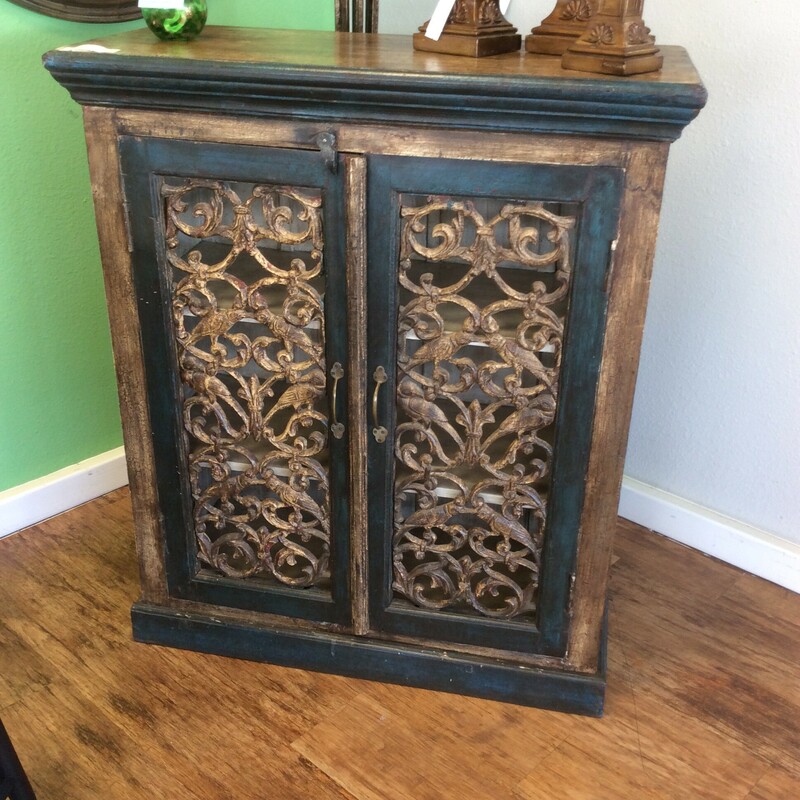 This is a Small Disstressed Cabinet with Crackel Brown and Turquoise Paint. The Cabinet has Swirl accent Doors and 3 Shelfs.
