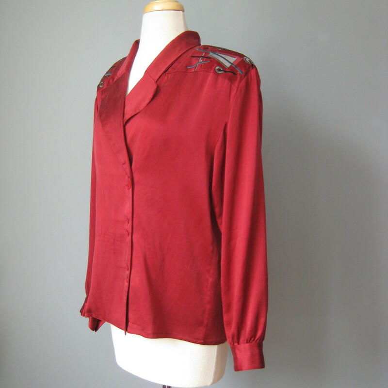 Gary Fabrikant washed silk blouse in deep almost burgundy red.<br />
Bit shoulder pads support a decorative shoulder and back yoke, embroidered and appliqued with gray, teal and red geometric designs.<br />
Asymmetrically set buttons pair off down the front<br />
Button Cuff Sleeves.<br />
Nicely made with an interior button to keep that neckline under control.<br />
Perfect condition.<br />
flat measurements:<br />
shoulder to shoulder: 20<br />
armpit to armpit: 20<br />
length: 25.5<br />
Underarm sleeve seam length: 18<br />
Width at hem:  19.5<br />
<br />
thanks for looking!<br />
#45422