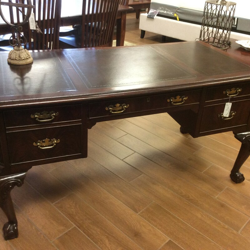 This is a Mahogany Heckman Office Desk. This Desk has a File Cabinet Drawer, 1 Middle Drawer and 2 Side Drawers. This Desk also features a Leather Top and Ball & Claw Feet.
