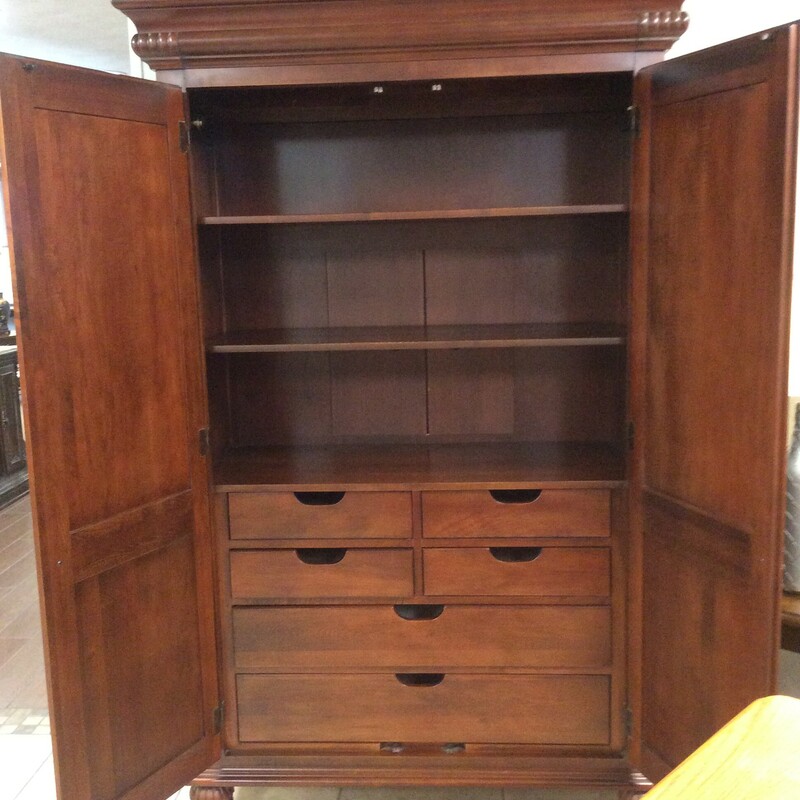 This is a Cherry Finish Ethan Allen Armiore. This Armiore has six drawers, two adjustable shelves, and a removable clothing rod. This beautiful piece has raised paneling exterior doors, and has a twisted rope trim.