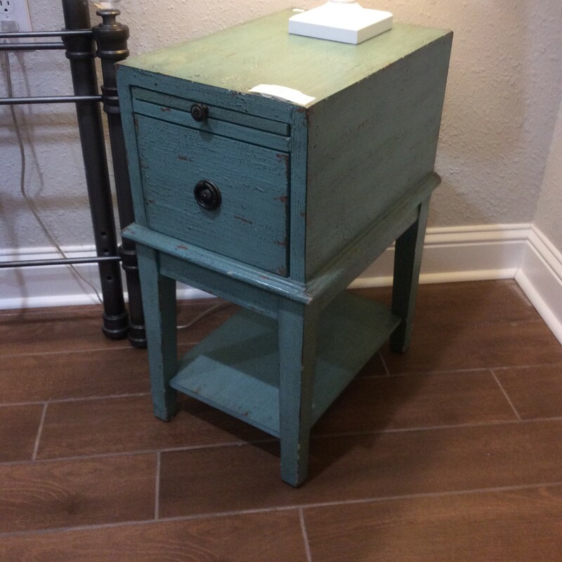 This is a Distressed Teal Night Stand. This Night Stand has 1 Standard size drawer, 1 flat extended drawer with Brass handles. This Night Stand also has a Shelf for storage underneith.