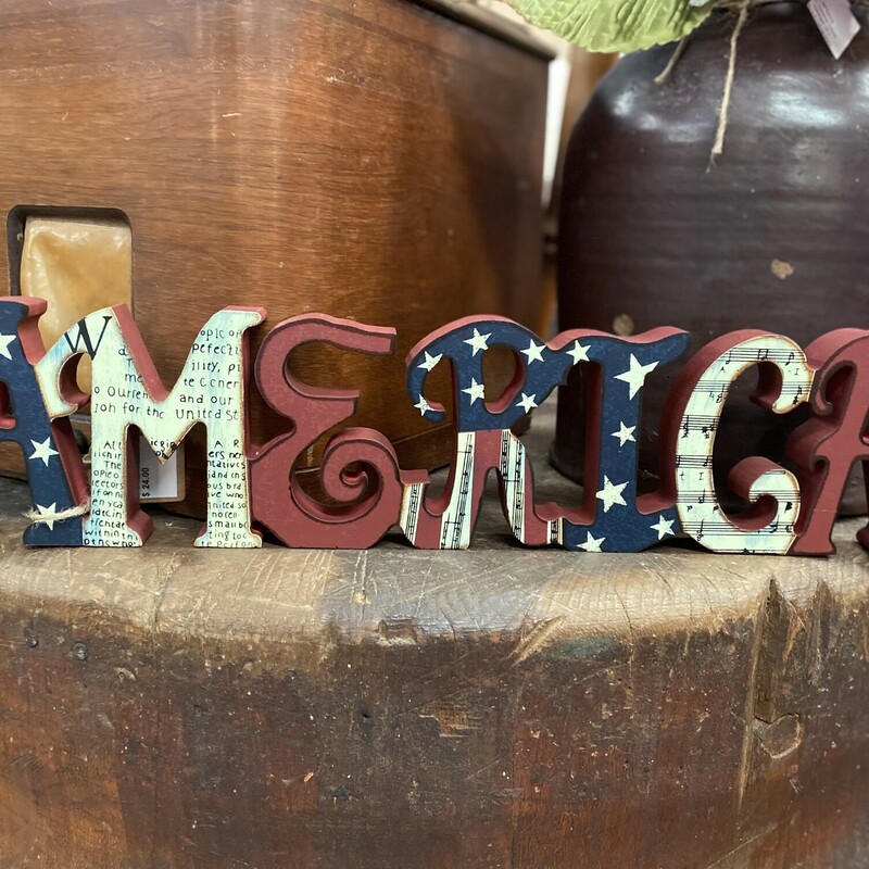 Show your prides with this America table sign. It is made of wood and features red, white, and blue stars and stripes. It is 4 inches high and 18 inches long