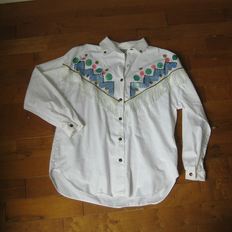 Vtg 80 Box Office, White, Size: XL<br />
Fun, somewhat western style white blouse by Box Office, made in the 1990s.<br />
It's got white fringe across the chest and a glittery blue and pink design painted on the front, a couple of jewels too.<br />
The back is plain.<br />
assembled in Mexico<br />
100% cotton<br />
<br />
excellent condition<br />
Marked size 16/18<br />
flat measurements:<br />
shoulder to shoulder: 24<br />
armpit to armpit: 23.5<br />
underarm sleeve seam: 16.5<br />
length: 26.25<br />
<br />
thanks for looking!<br />
#42873