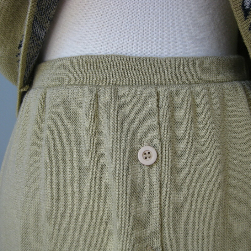 This darling two piece outfit  is I believe from the 70s.  It has a boxy cropped short sleeve top and and a funny skirt that has buttons all the way from the waist line to the hem, but the waist line itself has no opening so I am not sure why the buttons all the way from top to bottom.<br />
<br />
The beige knit has a border print in a black and white geometric pattern that appears at the hem of the skirt and top and ends of the full sleeves.<br />
<br />
Made in the USA<br />
<br />
Versatile, both pieces will work beautifully on their own.<br />
Both pieces are in excellent condition. No snags, holes, stains etc.<br />
<br />
<br />
Flat measurements:<br />
Top:<br />
Shoulder to shoulder: 19.75 designed with dropped shoulders so that seam will sit a bit down on your arm<br />
Armpit to armpit: 19.75<br />
Width at hem: 19.5<br />
Length: 15.75<br />
<br />
Skirt:<br />
Waist: 12 stretches a little<br />
hips: 19 a bit more stretch than the waistband<br />
Length: 21.5<br />
<br />
Thanks for looking!<br />
#42699