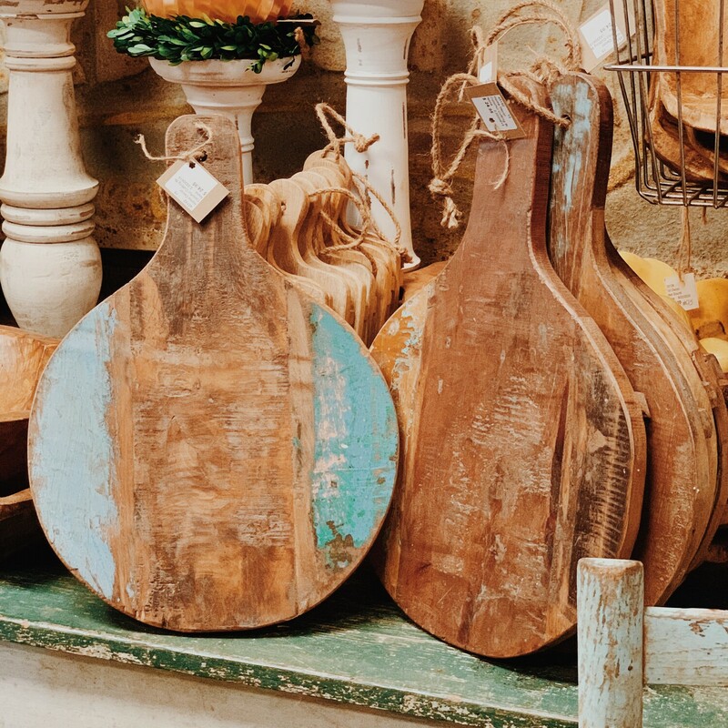 These round, wooden cutting boards feature distressed pops of color! They measure 17 inches long by 12 inches wide.