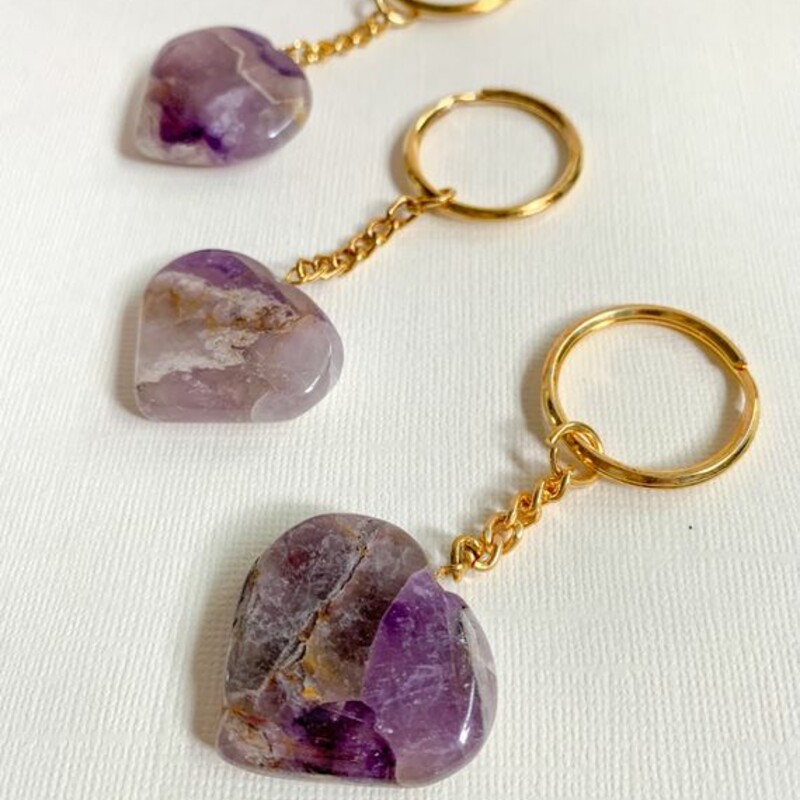 Amethyst Crystal Keychain, Purple
Carry the power of crystal energy with you, with these adorable natural gemstone keychain.

Heart- shaped hand carved crystals are attached to sturdy gold color chain and ring.

Amethyst Healing Properties
• Promotes intuition, calm and stillness
• Eliminates stress and worry
• Works with crown chakra

Key chain measures 3.25 inches long
Heart measures 1.2 inch across

Note: Crystals may vary slightly by color and size