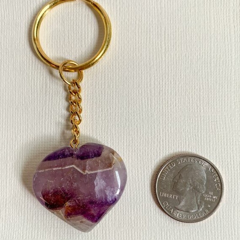 Amethyst Crystal Keychain, Purple
Carry the power of crystal energy with you, with these adorable natural gemstone keychain.

Heart- shaped hand carved crystals are attached to sturdy gold color chain and ring.

Amethyst Healing Properties
• Promotes intuition, calm and stillness
• Eliminates stress and worry
• Works with crown chakra

Key chain measures 3.25 inches long
Heart measures 1.2 inch across

Note: Crystals may vary slightly by color and size