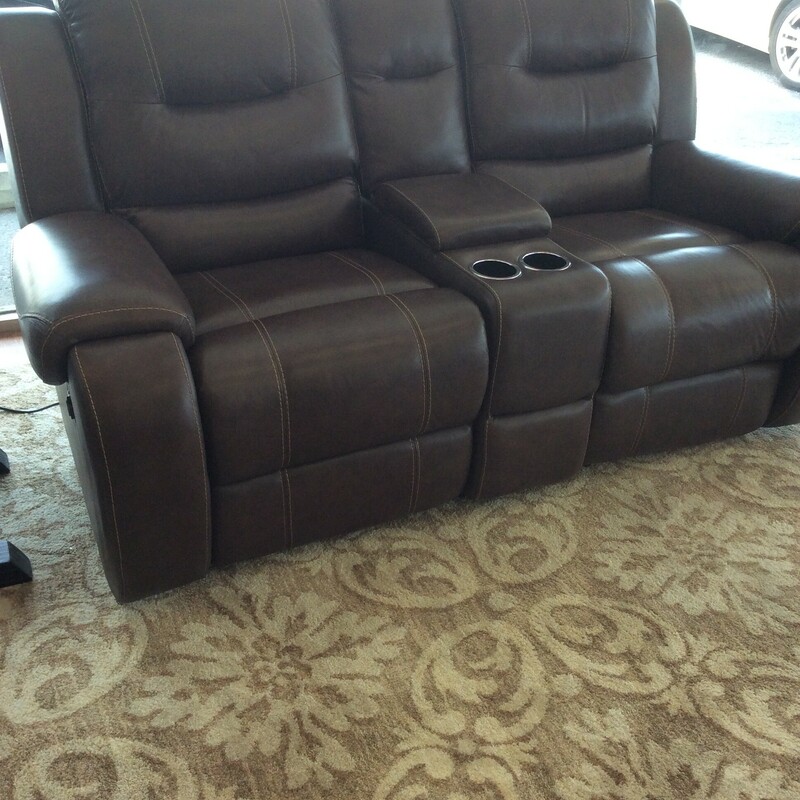 This  brown leather electric reclining sofa has stiched detailing and a storage/cupholder in the center.