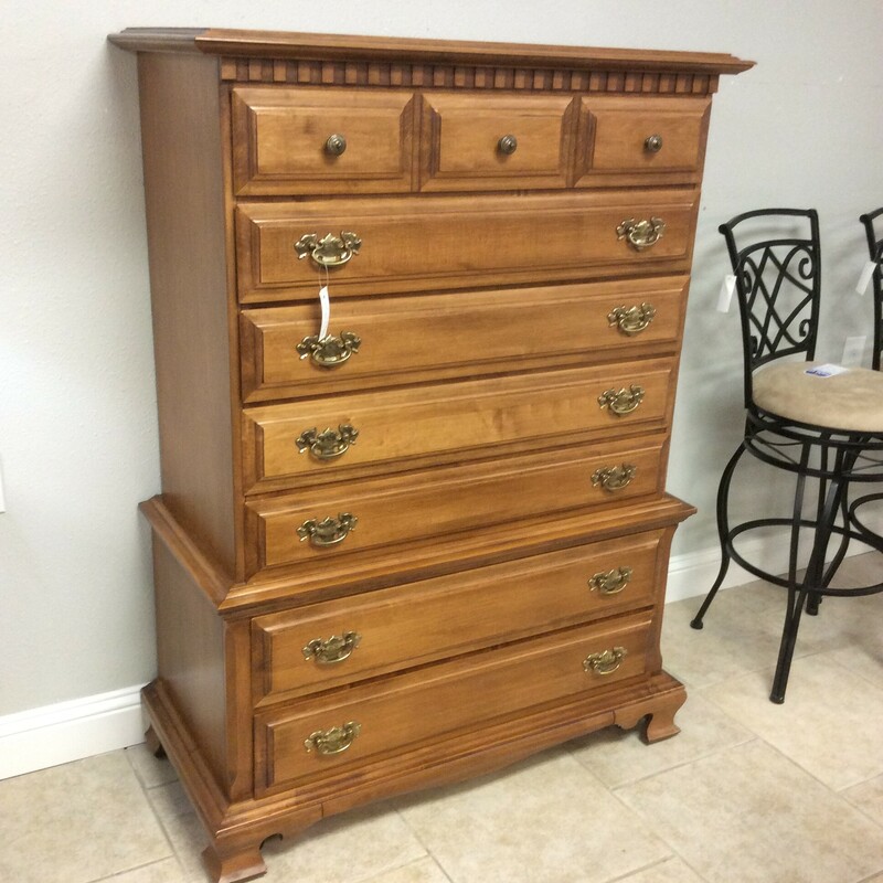 This Spraque Carlton chest of drawers has a light pine finish and antique brass hardware.