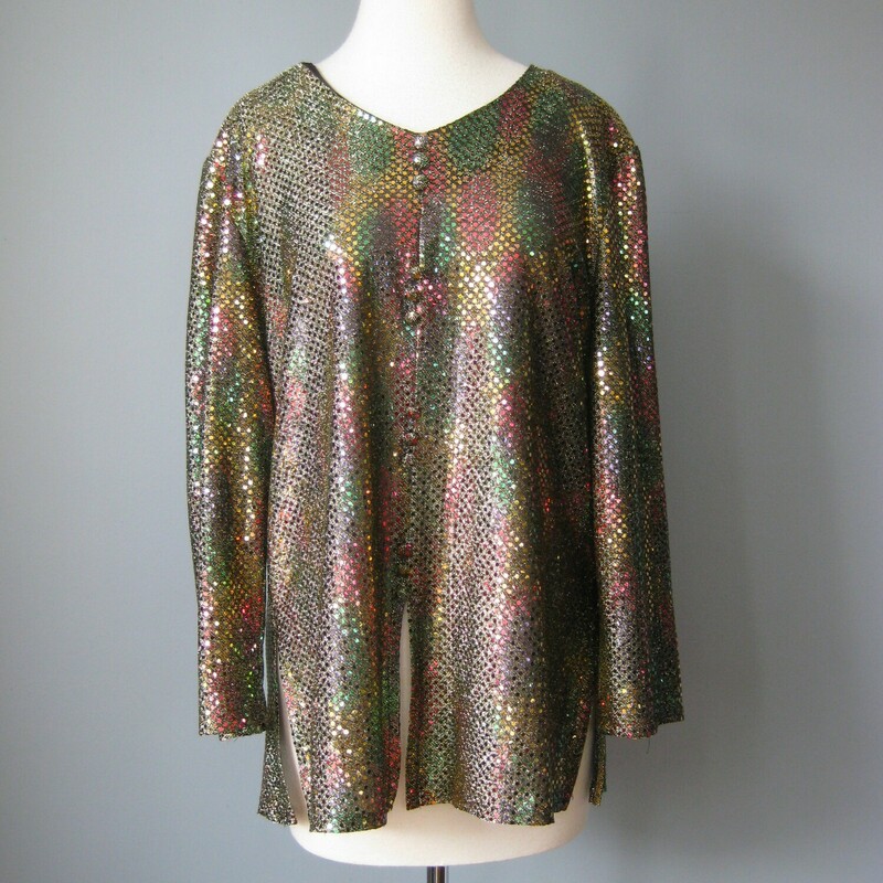 Vtg Another Time Glitter, Gold, Size: Large<br />
Not so subtle glimmer in a longish pullover tunic that looks like a buttondown.<br />
It's by Another Time and was made in the 1970s<br />
50% rayon 30% poly 20% metalllic<br />
<br />
The base color is gold but the small reflective metallic circles disperse light into myriads of colors.<br />
Marked size 12<br />
Made in the USA<br />
buttons are decorative<br />
<br />
flat measurements:<br />
shoulder to shoulder : 17.35<br />
armpit to armpit: 24<br />
waist: 22<br />
Hip: free, there are slits at edge side<br />
length: 27.75<br />
<br />
Excellent vintage condition! Like new really<br />
<br />
<br />
thank for looking!<br />
#42954