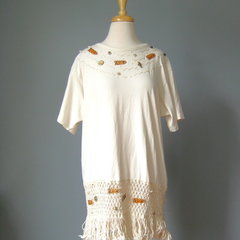 Sesucci Beach Cover Up, Cream, Size: Large
Beach Dress / Vtg 80s / Sesucci ivory fringed Tee shirt

Beach Dress / Vtg 80s / Sesucci ivory fringed Tee shirt dress with beach charms
Super fun vintage swim coverup from Sesucci.
It's a long tee shirt with a deep crocheted hem.
Little plastic fishes swim through waves and seashells painted on the chest and in the hem.
Off white, cream color.
100% cotton
Made in the USA
Marked size M
Flat measurements
Shoulder to Shoulder: 19.75
Armpit to Armpit: 24
Waist: 22
Hip: 20.5
Length: 31

Excellent condition!
Thanks for looking.
#42943