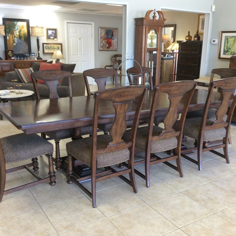 This is a beautiful dark stained wood with stiching detail and includes 2 leafs. This table also has 8 upholstered, nailhead trim chairs.