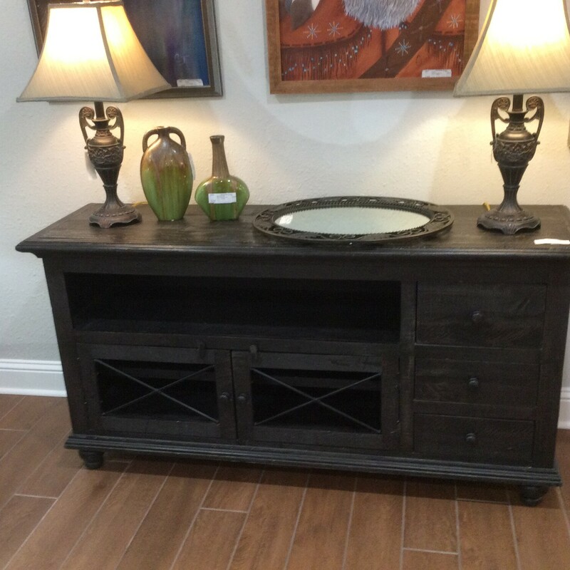 This is a black distressed media cabinet with 3 side drawers, double barn cabinet doors with 2 shelfs.