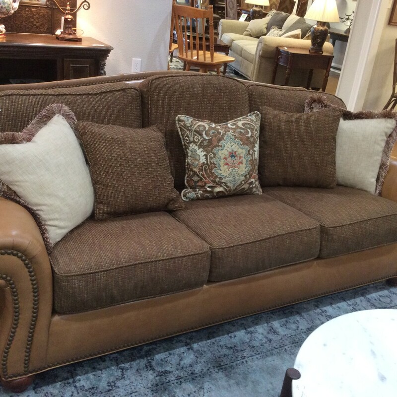 This is a beautiful Ethan Allen tan 3 seater sofa. This sofa has a tan leather and brown woven linen removable cushions. This sofa also features nailhead trim and 5 decorative pillows.
