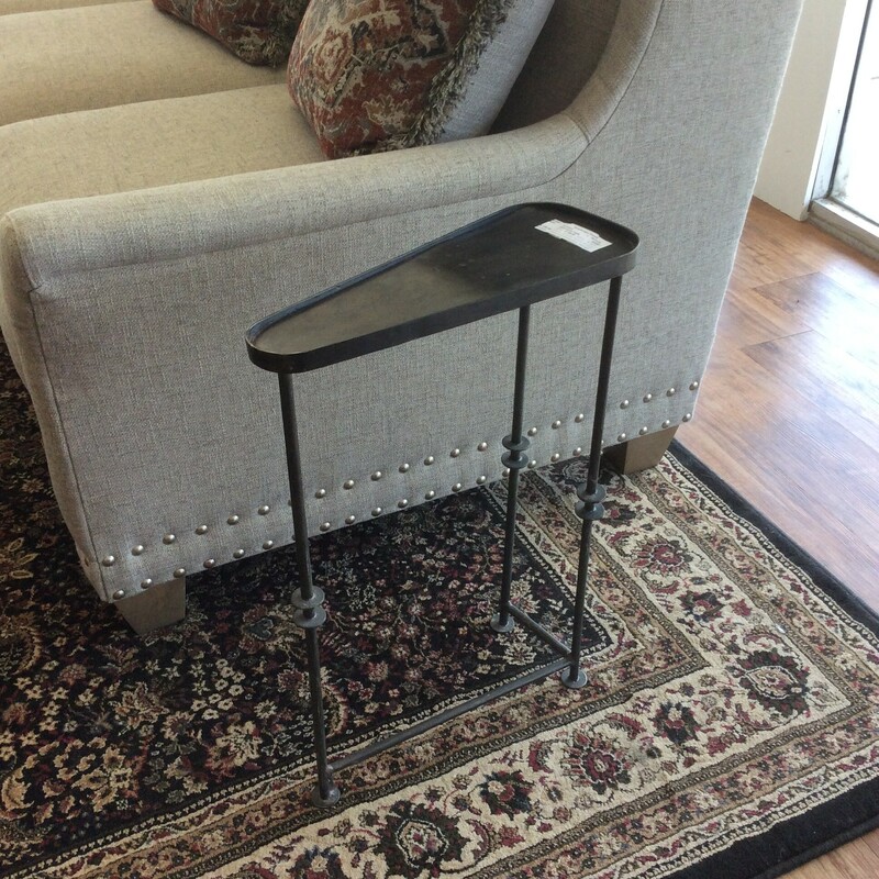 This is a dark metal, triangle shaped drinking table. This table has 3 round legs with circle detailing.