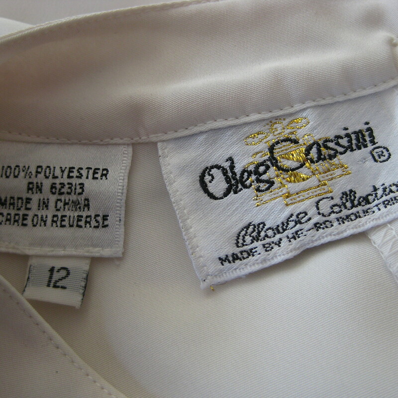 Simple long sleeve white top with little rosettes formed from sequins sewn all over the front.<br />
It's by Oleg Cassini<br />
two buttons and loops the back of the neck<br />
button cuffs<br />
<br />
Marked size 12<br />
flat measurements:<br />
shoulder to shoulder: 16.25<br />
armpit to armpit: 22.75<br />
length: 27.5<br />
Underarm sleeve seam length: 18<br />
Width at hem:  21.5<br />
<br />
thanks for looking!<br />
#43101