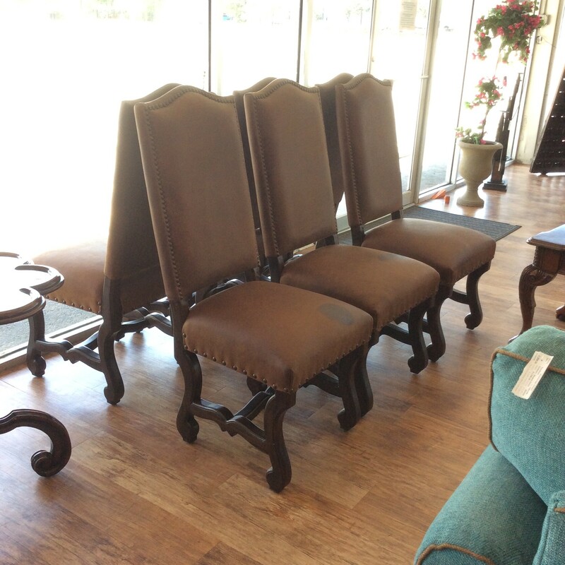 This is a set of  6 Sonora Leather Chairs. These chairs are a light tan color with dark brown legs. These chairs also feature nail head trim.