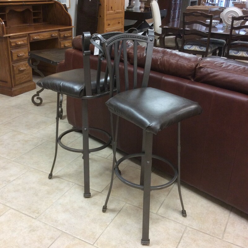 This is a pair of swivel, iron bar stools with vinyl seating.