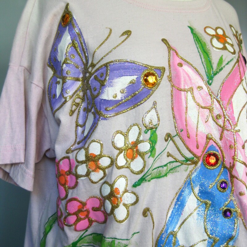 Jeweled Tee, Pink, Size: XL<br />
<br />
Totally gorgeous white tee shirt with large blue and pink painted butterflies enhanced with gold and a few jewels.<br />
Great colors and amazing condition, the tee at the base is kind of a dulled white perhaps it was pink initially but the butterflies and gold paints are intact and very vibrant.<br />
Marked One Size fits all<br />
made in the USA<br />
100% cotton<br />
<br />
flat measurements:<br />
shoulder to shoulder: 23<br />
armpit to armpit: 23.5<br />
length: 24.5<br />
width at hem: 22.25<br />
<br />
Thanks for looking!<br />
#43116