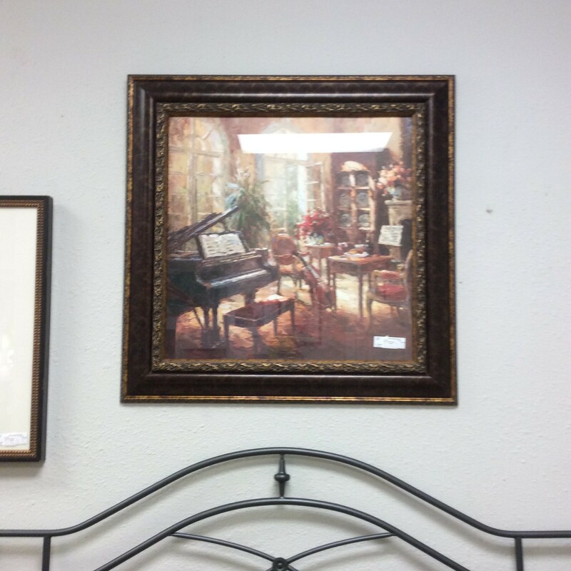 This is a bronze and gold framed picture of a piano/ music room.