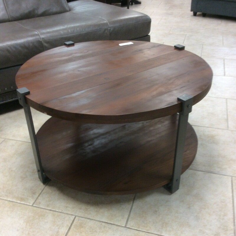 This modern rustic style coffee table has a metal frame with a wood top and shelf.