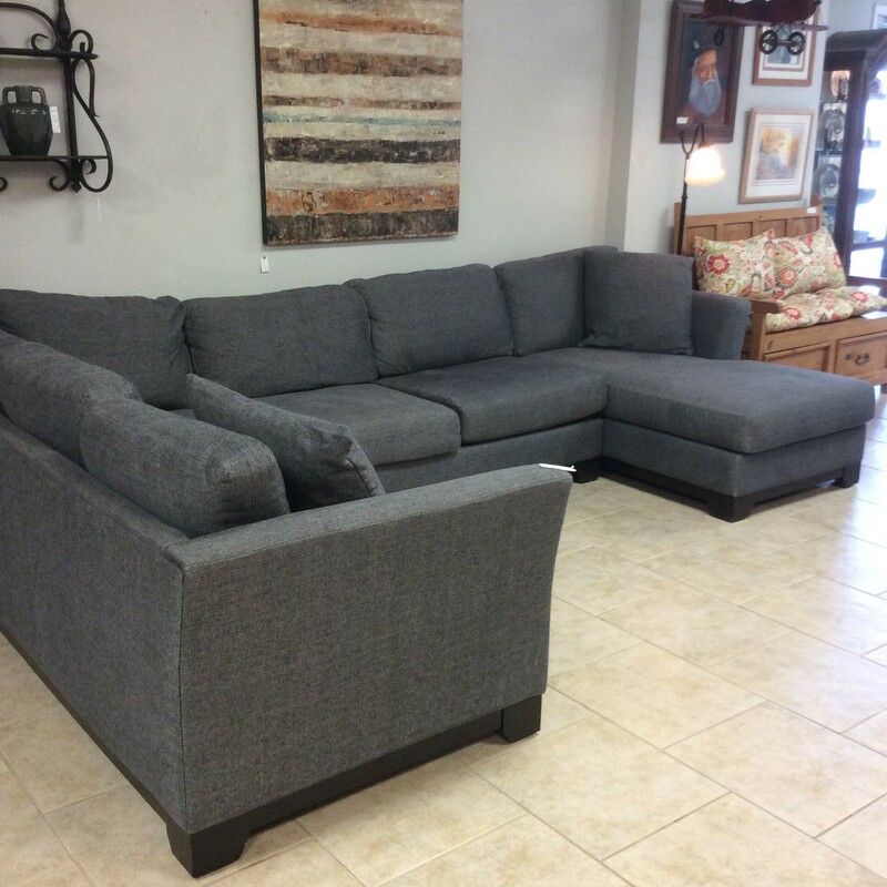 This Jonathan Louis sectional has a built in chaise lounge and is upholstered in a grey tweed fabric.