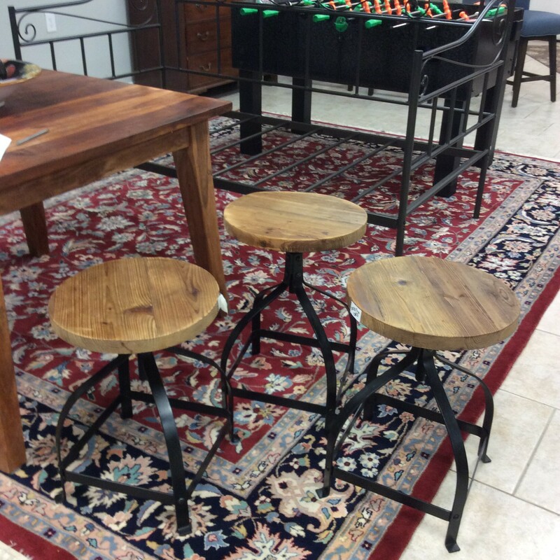 This set of 3 adjustable stools have round wooden seats with metal bases. They adjust by spinning the seat around in either direction to raise or lower
