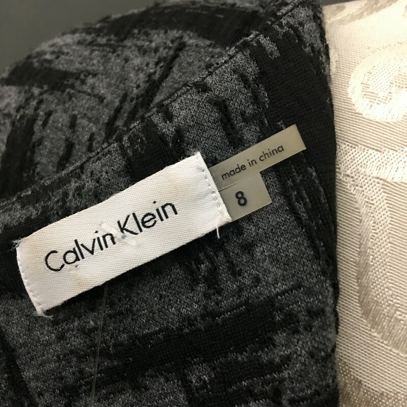 Calvin Klein Poly Knit, Pattern, Size: 8<br />
Calvin Klein polyester blend knit Empire dress black brush strokes on dark grey, cap sleeves, 2 buttons detail on front, square neckline, zip back,<br />
15.3 oz