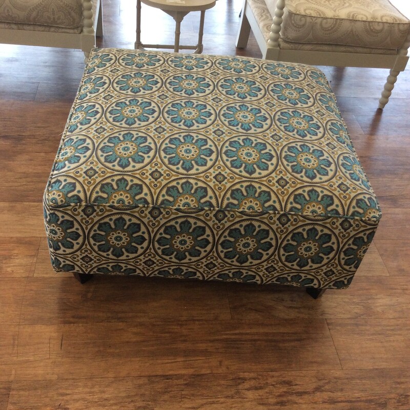 This is a multi colored, linen floral Ottoman.