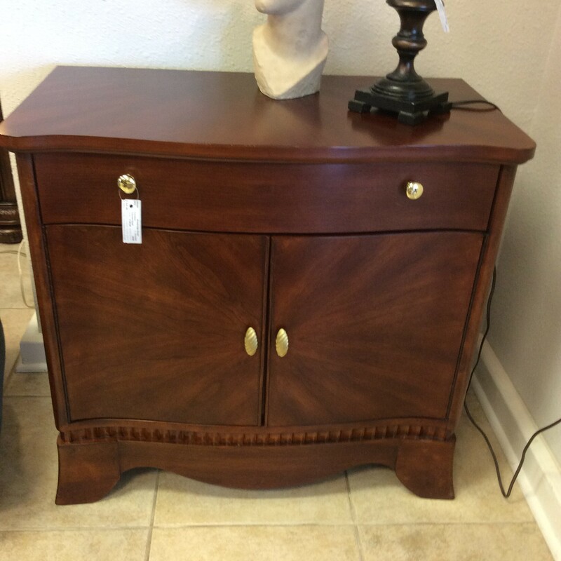 This transitional Console Chest is done in a light cherry finish with brass hardware.