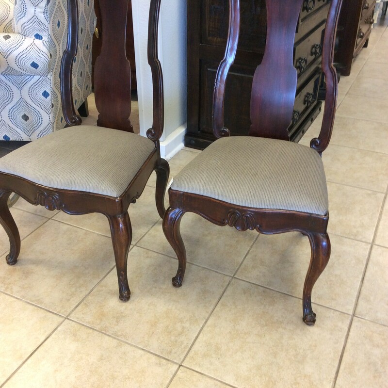 This pair of dining chairs have upholstered seats with carved details.