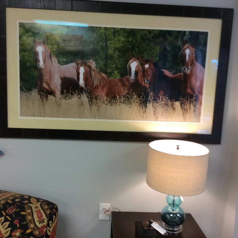 This oversized photo of a group of horses is nicely framed in a rustic style frame.