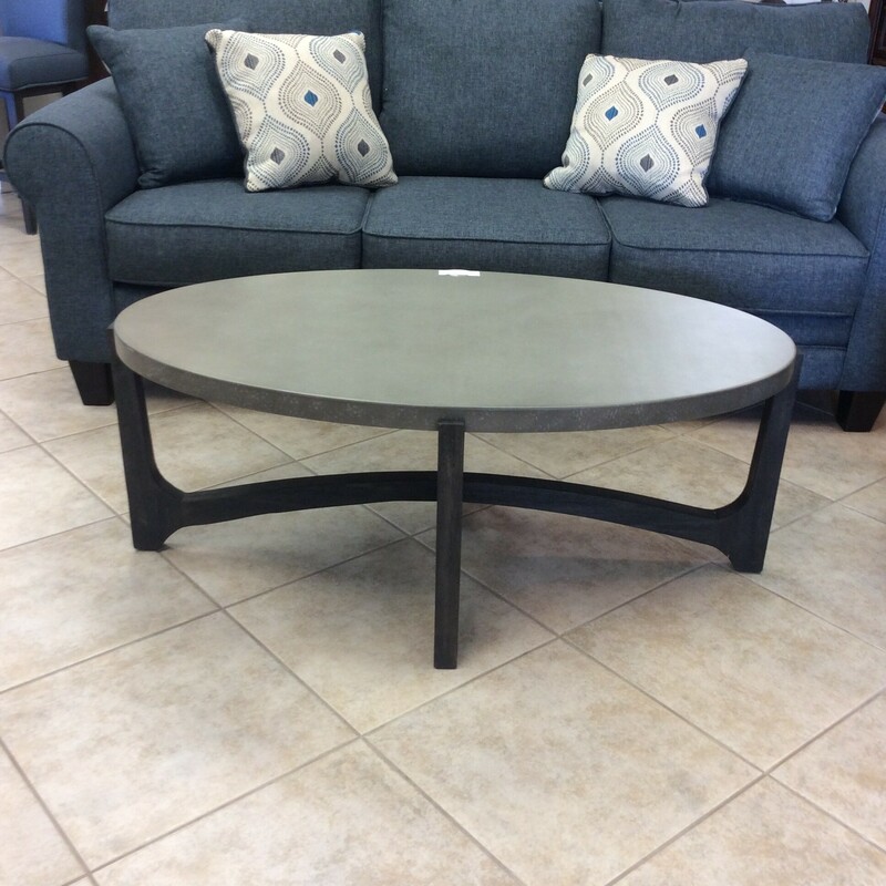 This oval coffee table has a gray composite top with a gray wood stained base.