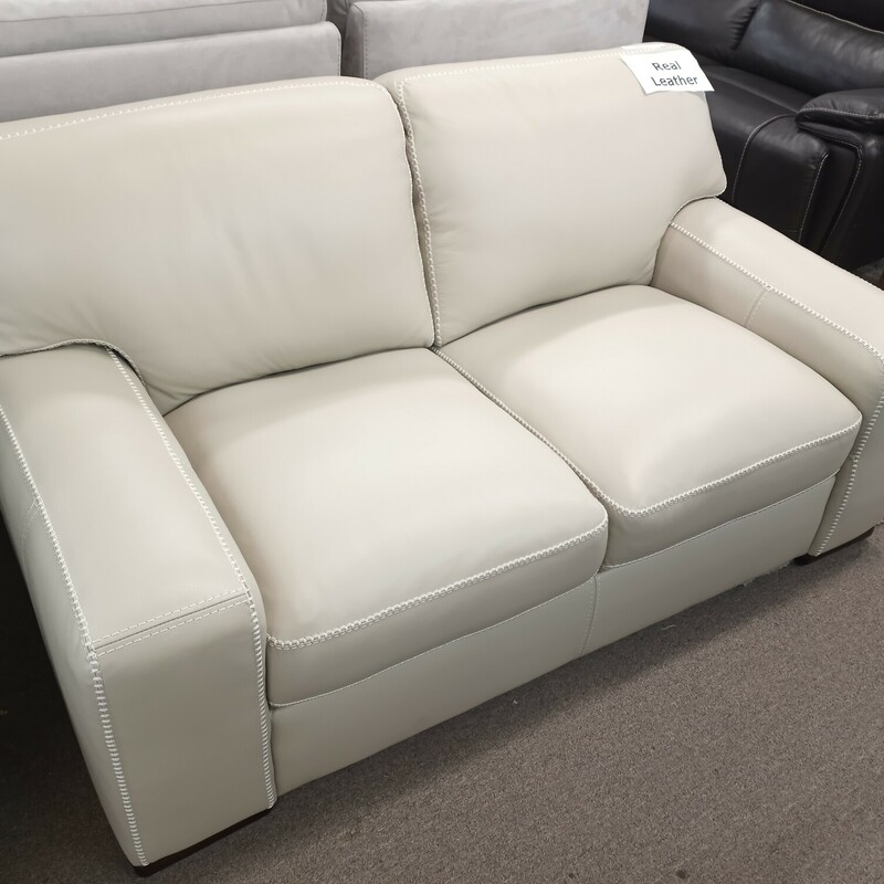 Cream Leather Loveseat,
    Color: Beige
    Top Grain Leather with Matching Split Leather on Sides and Back
    Contrast and Decorative Stitching adds a layer of stylish design
    2.2 high density foam seat cores with a blend down that creates an initial softness with underlying support
    Foam seat cushions support you while staying comfortable
    Back cushions feature polyester fibers which are baffled in a woven fabric bag to prevent sagging and to adapt to your personal comfort needs
    Solid wood legs are covered in an espresso finish
    Furniture grade engineered wood, corner blocked and glued in all key joint areas; entire frame is encapsulated with a layer of wood laminate then padded with foam and/or rolled fiber- no leather ever touches raw wood

Dimensions:

    68” L x 39” W  x 35” H
    Seat Depth: 22.8”
    Seat Height: 20”
    Seat Width: 22.8”
    Arm Height: 24”
    Leg Height: 2”
    Weight: 117.7 lbs